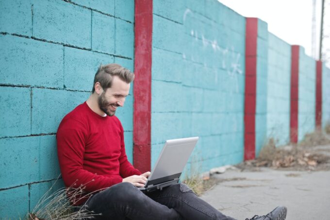 Man in red sweater holding a laptop. Concept for online businesses.