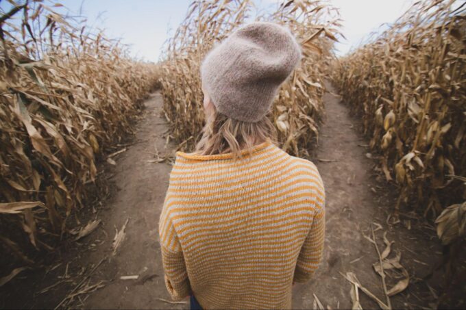  A woman trying to decide what path to take in a corn maze